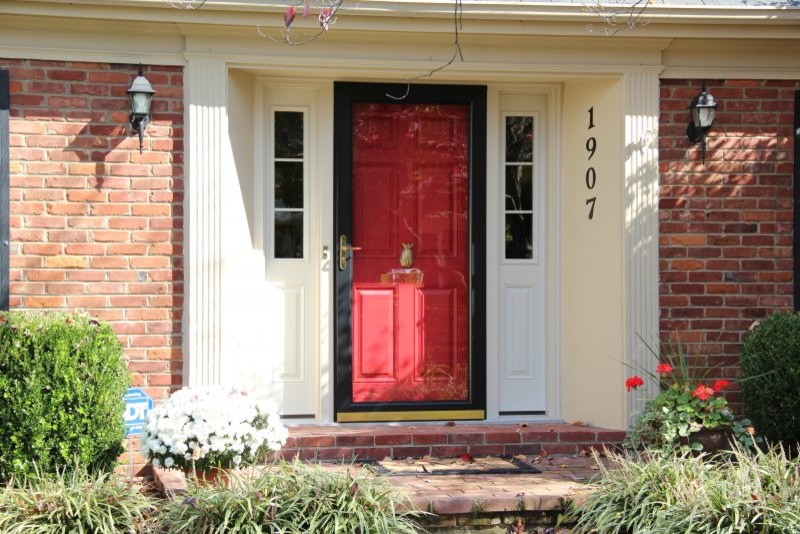 На фото: входная дверь в классическом стиле с одностворчатой входной дверью и красной входной дверью