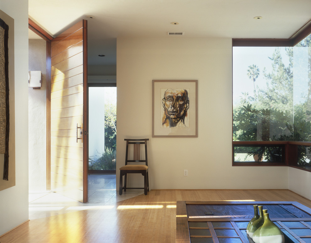 Foto de entrada minimalista con paredes beige, puerta simple y puerta de madera en tonos medios