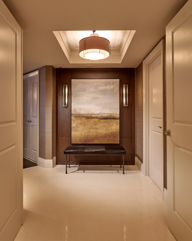 Cette photo montre un grand vestibule chic avec un mur beige et un sol en marbre.