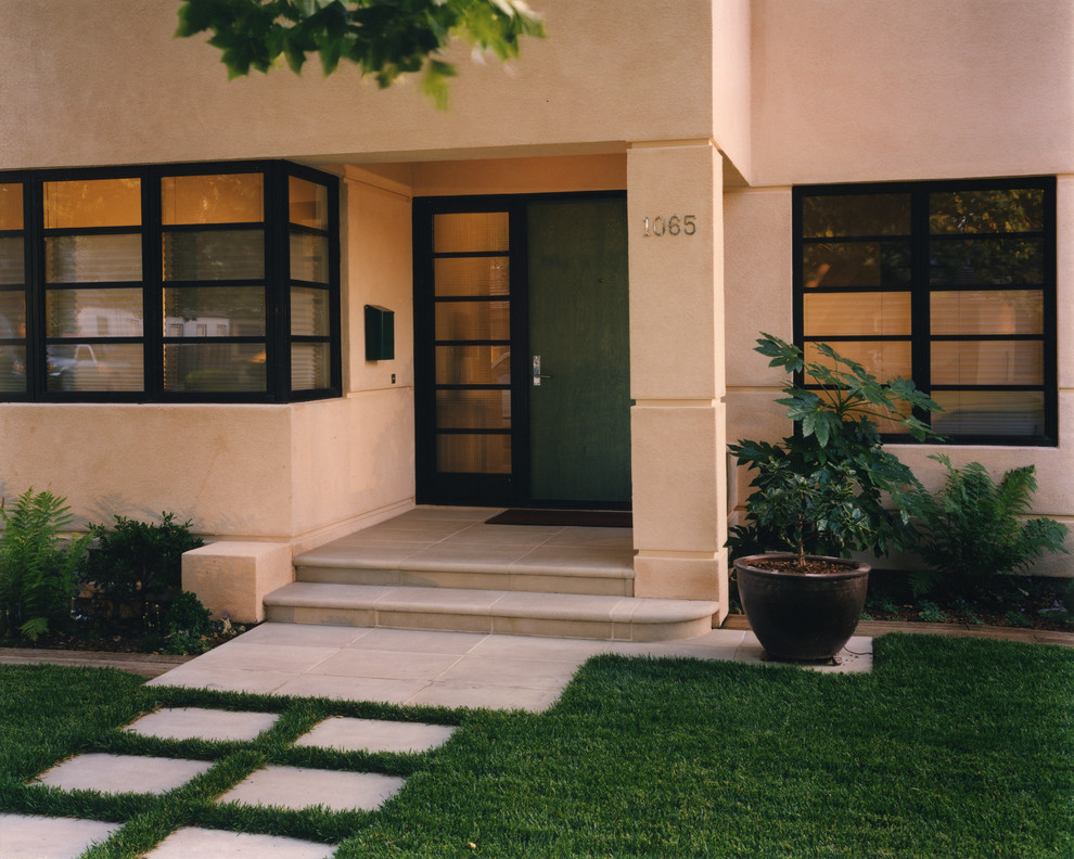 Exemple d'une entrée tendance avec une porte simple et une porte verte.