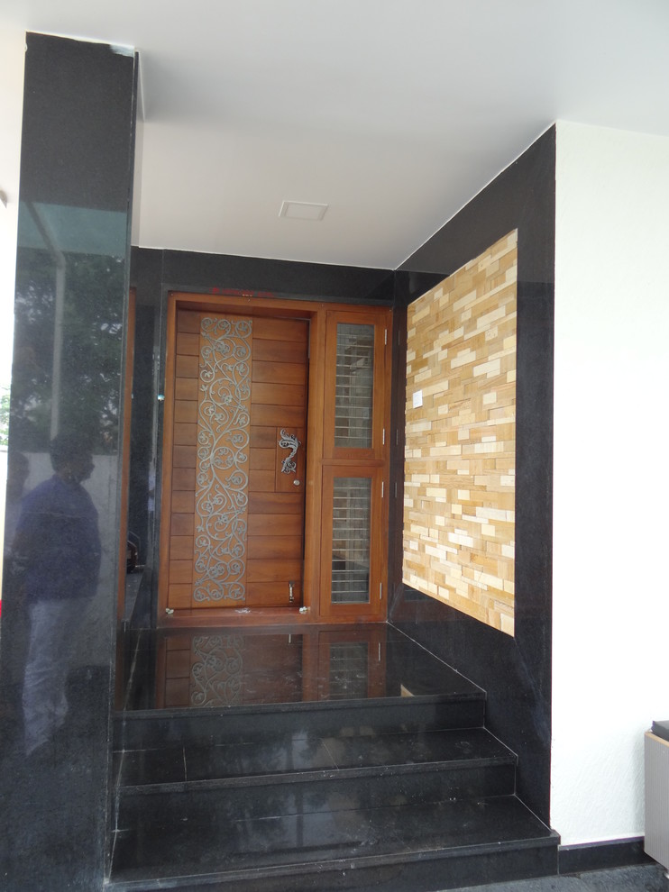 Immagine di un ingresso o corridoio minimalista con una porta singola e una porta in legno bruno