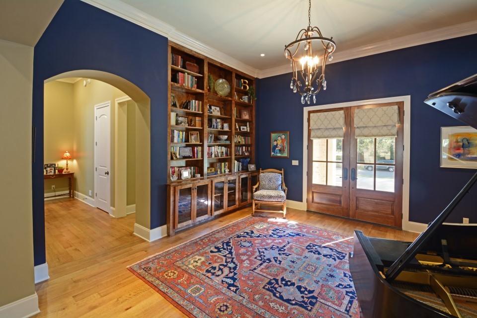Imagen de vestíbulo clásico de tamaño medio con paredes azules, suelo de madera clara, puerta doble y puerta de madera en tonos medios