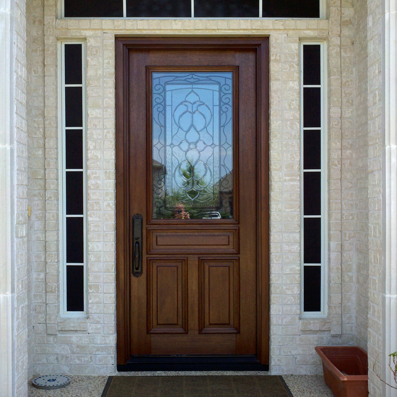 Cette image montre une porte d'entrée traditionnelle avec une porte simple et une porte en bois foncé.