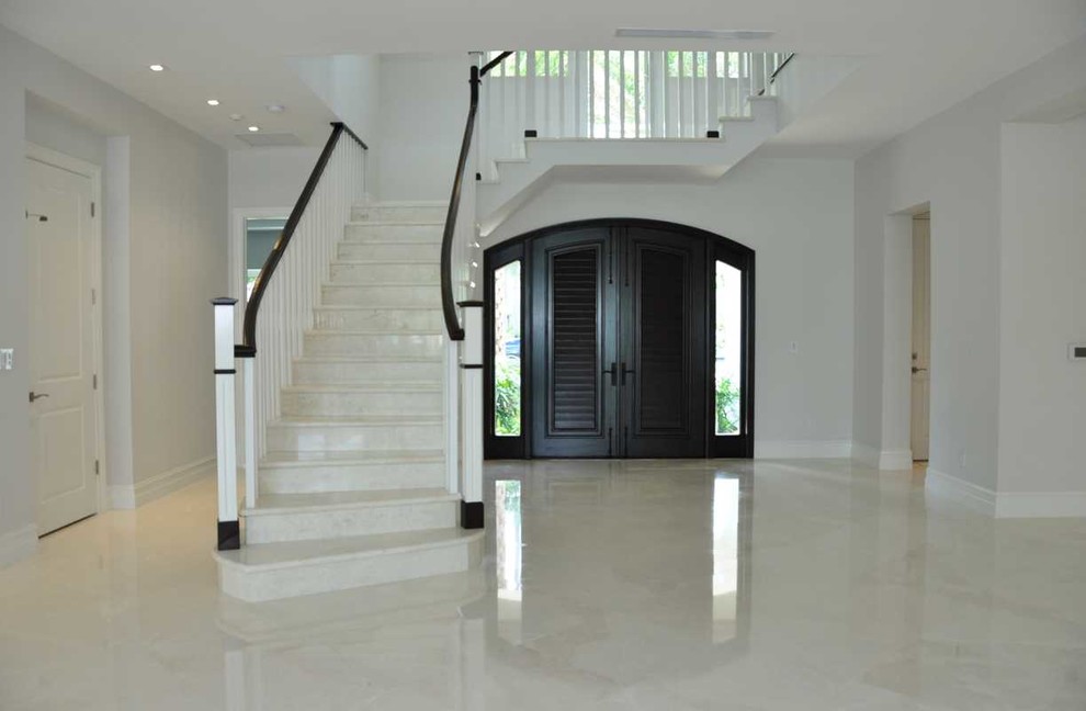 Mid-sized island style porcelain tile and white floor entryway photo in Miami with white walls and a dark wood front door