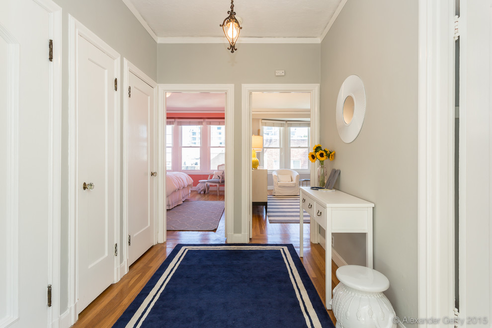 Diseño de hall tradicional pequeño con suelo de madera en tonos medios, puerta simple y puerta blanca