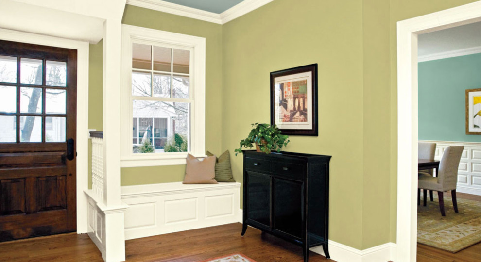 Imagen de entrada clásica con paredes verdes, suelo de madera oscura, puerta simple, puerta de madera en tonos medios y suelo marrón