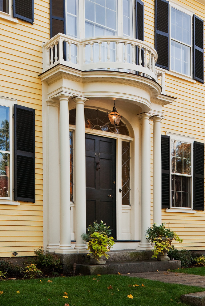 ボストンにあるラグジュアリーな広いトラディショナルスタイルのおしゃれな玄関 (黒いドア、黄色い壁) の写真