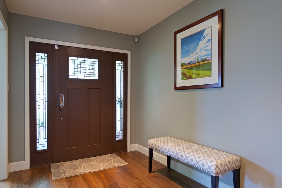 Ispirazione per una porta d'ingresso tradizionale di medie dimensioni con pareti grigie, pavimento in legno massello medio, una porta singola e una porta in legno scuro