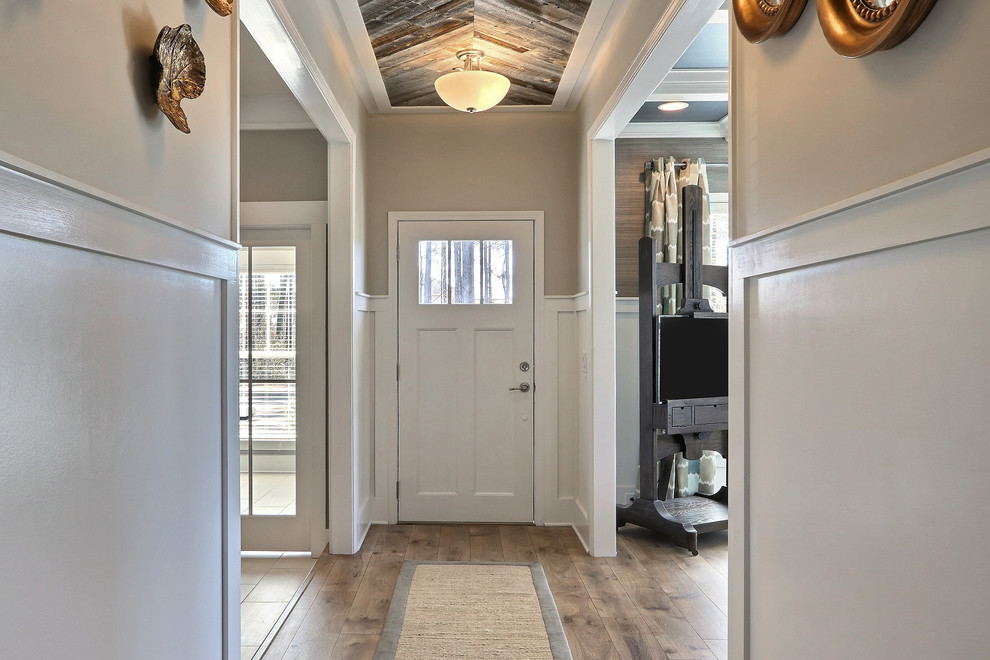 Inspiration pour un hall d'entrée traditionnel de taille moyenne avec un mur beige, parquet foncé, une porte simple et une porte blanche.