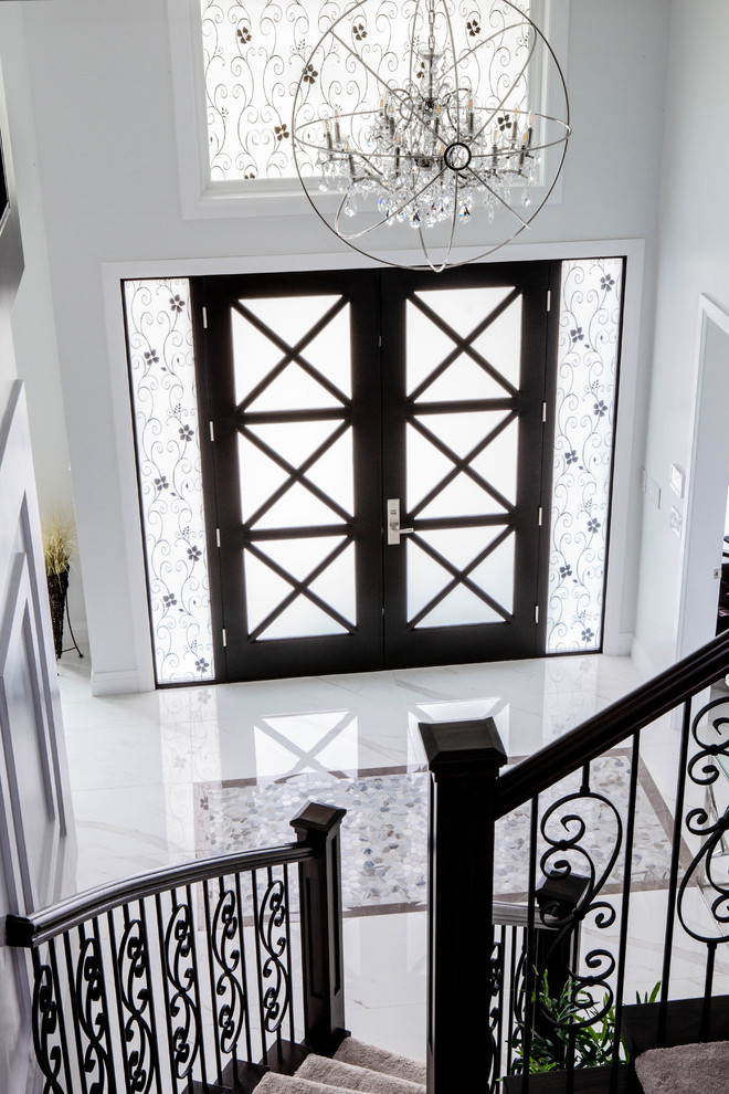 На фото: большая входная дверь в стиле неоклассика (современная классика) с белыми стенами, мраморным полом, двустворчатой входной дверью, стеклянной входной дверью и белым полом