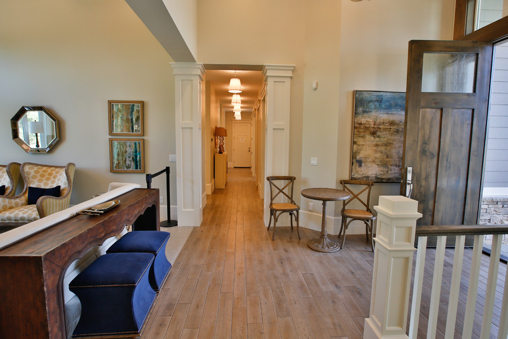 Großes Foyer mit weißer Wandfarbe, Einzeltür, dunkler Holzhaustür und hellem Holzboden in Salt Lake City