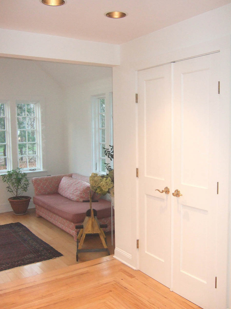 Cette photo montre un hall d'entrée chic de taille moyenne avec un mur blanc, parquet clair, une porte double et une porte blanche.