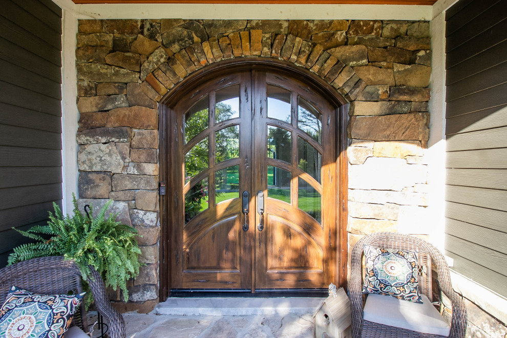 На фото: входная дверь среднего размера в викторианском стиле с коричневыми стенами, полом из сланца, двустворчатой входной дверью, входной дверью из дерева среднего тона и разноцветным полом с