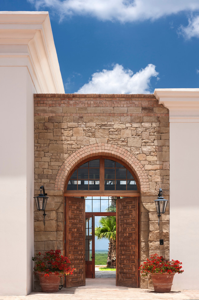 На фото: входная дверь в стиле фьюжн с кирпичным полом и двустворчатой входной дверью