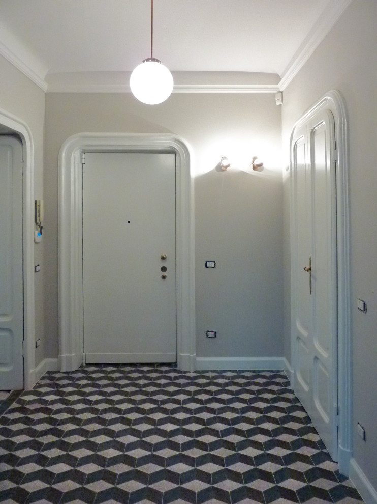 Ispirazione per un grande ingresso bohémian con pareti grigie, una porta singola, una porta bianca e pavimento multicolore