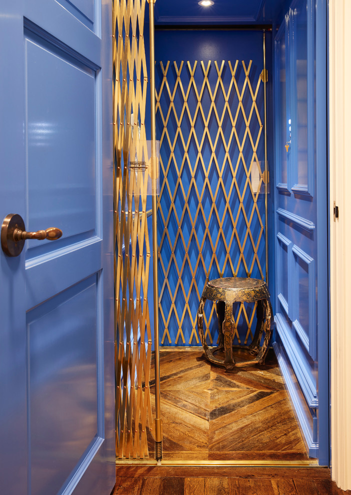 Diseño de entrada clásica renovada de tamaño medio con paredes azules, suelo de madera en tonos medios, puerta simple y puerta azul