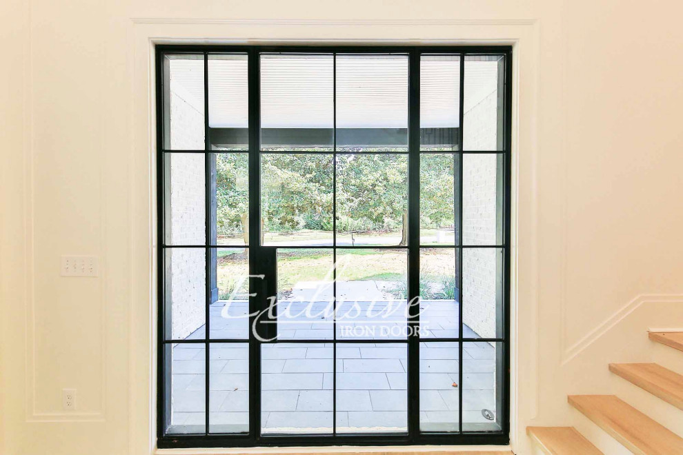 Immagine di una porta d'ingresso contemporanea di medie dimensioni con pareti bianche, una porta singola e una porta nera