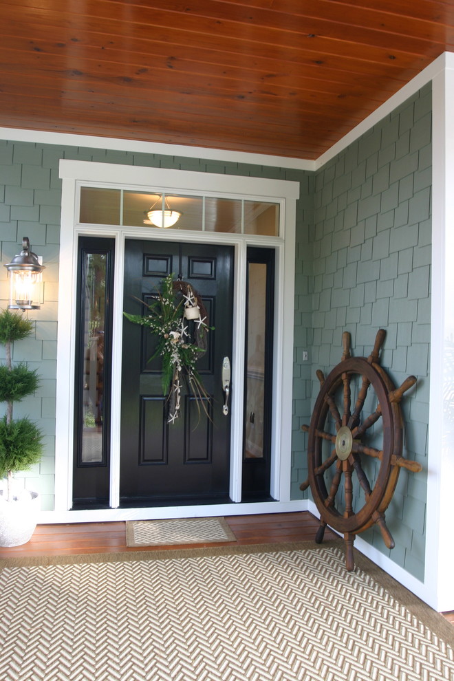 На фото: входная дверь в классическом стиле с одностворчатой входной дверью и черной входной дверью