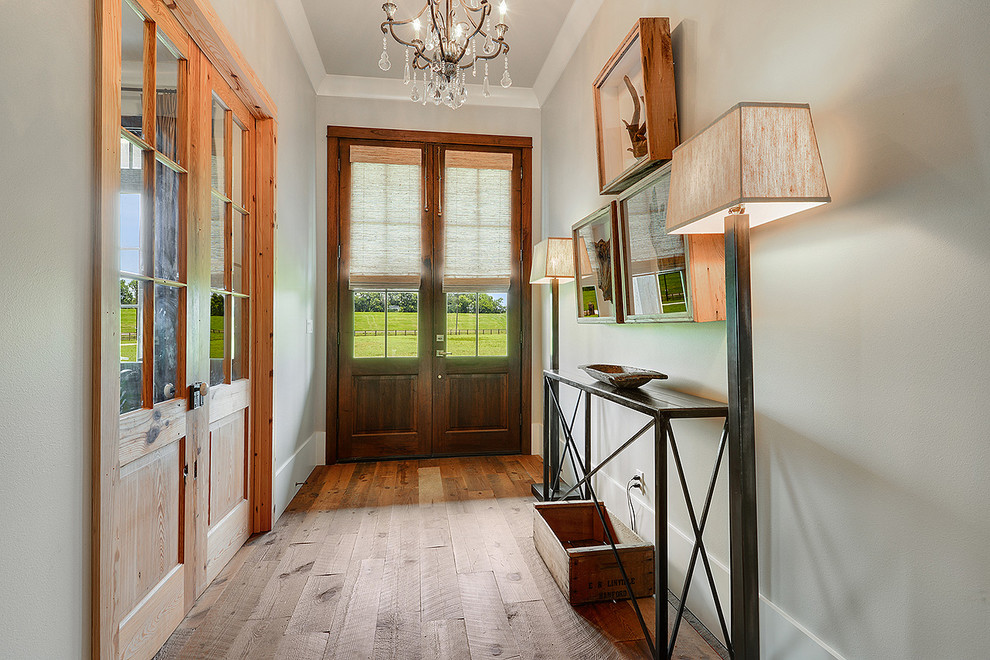 Modelo de hall de estilo de casa de campo de tamaño medio con suelo de madera clara, puerta doble y puerta de madera oscura