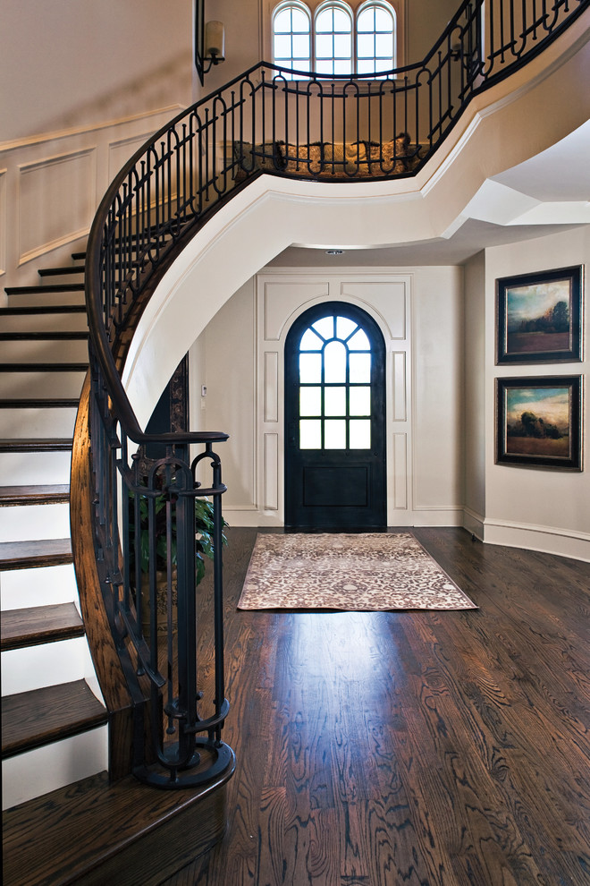 ダラスにあるトラディショナルスタイルのおしゃれな玄関ドア (ベージュの壁、濃色無垢フローリング、濃色木目調のドア、茶色い床) の写真