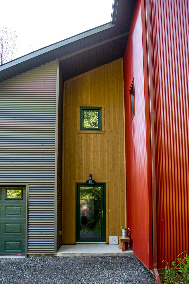 Foto på en mellanstor rustik foajé, med bruna väggar, betonggolv, en enkeldörr, en grön dörr och grått golv