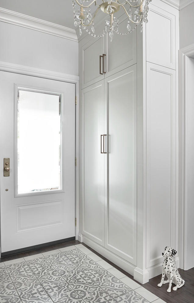 Idée de décoration pour un petit hall d'entrée tradition avec un mur blanc, un sol en carrelage de céramique, une porte simple, une porte blanche et un sol gris.