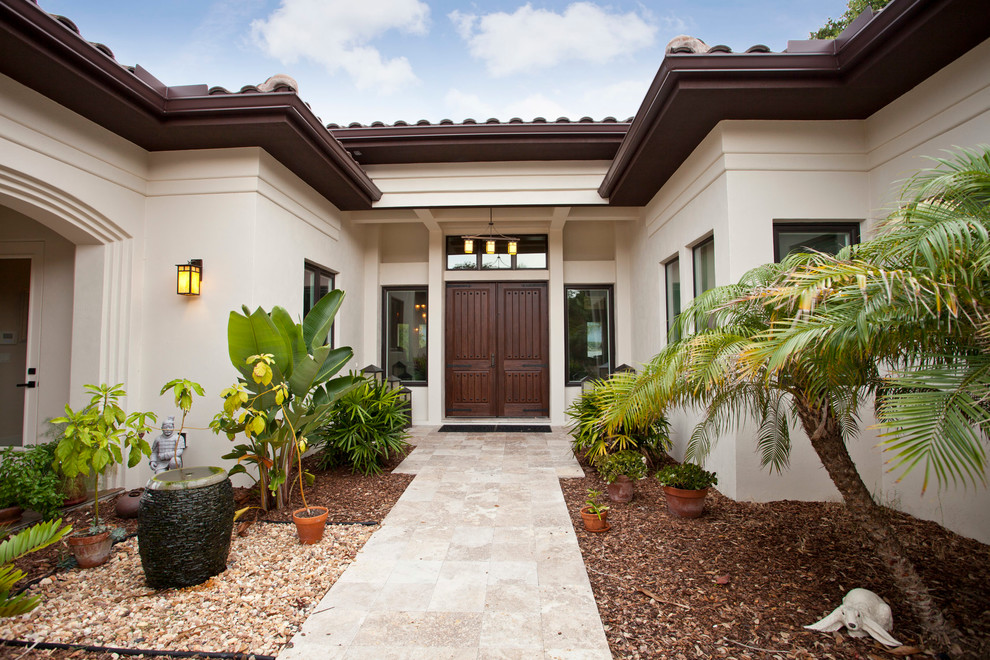 Mediterrane Haustür mit beiger Wandfarbe, Travertin, Doppeltür und dunkler Holzhaustür in Orlando