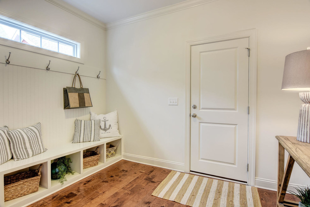 Foto di un ingresso con anticamera chic di medie dimensioni con pareti bianche, pavimento in legno massello medio, una porta a pivot, una porta bianca e pavimento marrone