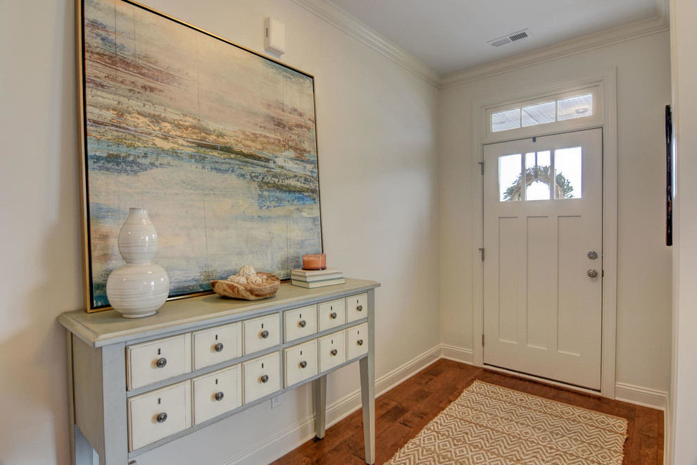 Idee per un ingresso minimalista di medie dimensioni con pareti bianche, pavimento in legno massello medio, una porta a pivot, una porta arancione e pavimento marrone