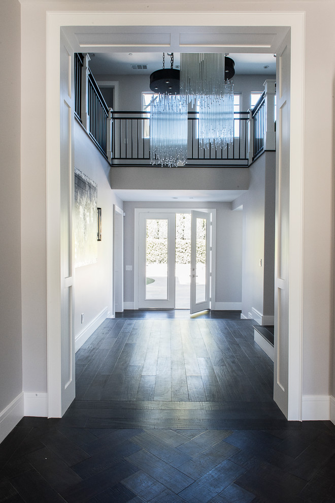 Trendy dark wood floor and brown floor entryway photo in Orange County