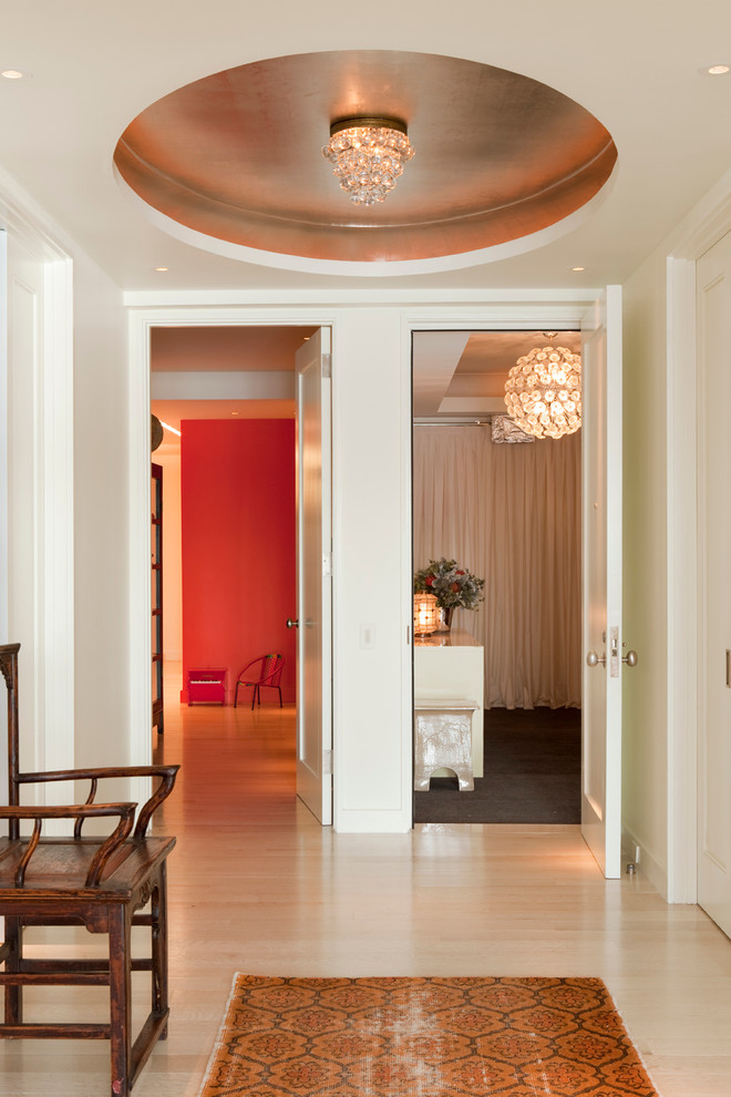 Photo of a contemporary entrance in New York with white walls and light hardwood flooring.