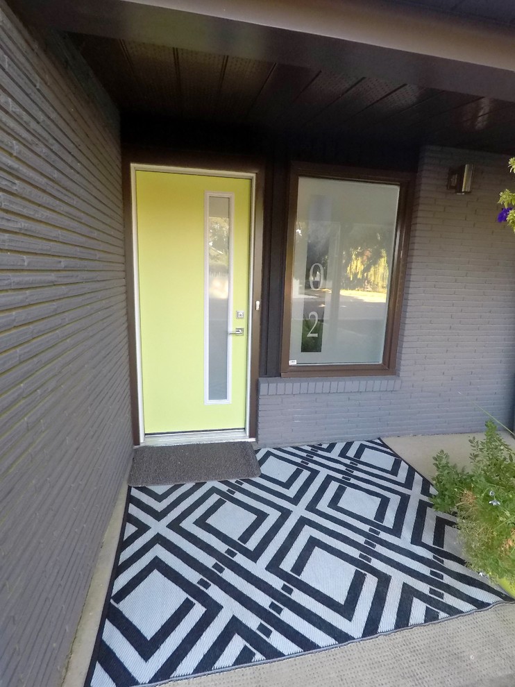 Свежая идея для дизайна: входная дверь среднего размера в стиле ретро с серыми стенами, бетонным полом, одностворчатой входной дверью, зеленой входной дверью и серым полом - отличное фото интерьера