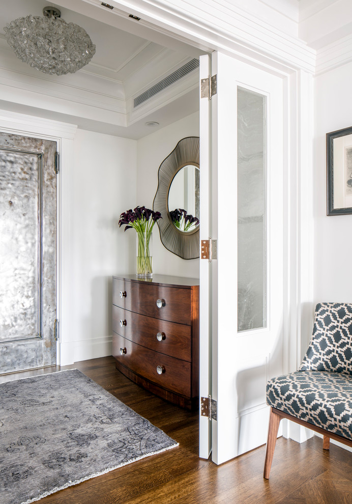 Idee per un piccolo ingresso classico con pareti bianche, pavimento in legno massello medio, una porta singola, una porta in metallo e pavimento marrone
