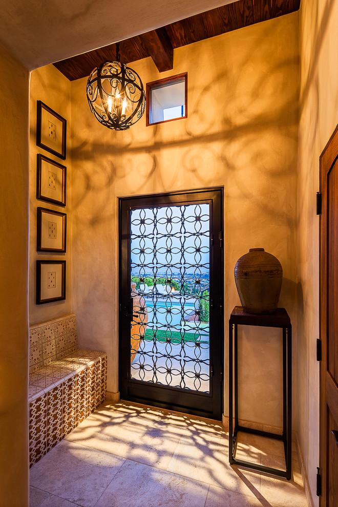 Design ideas for a mediterranean hallway in Santa Barbara with beige walls, a single front door and a black front door.