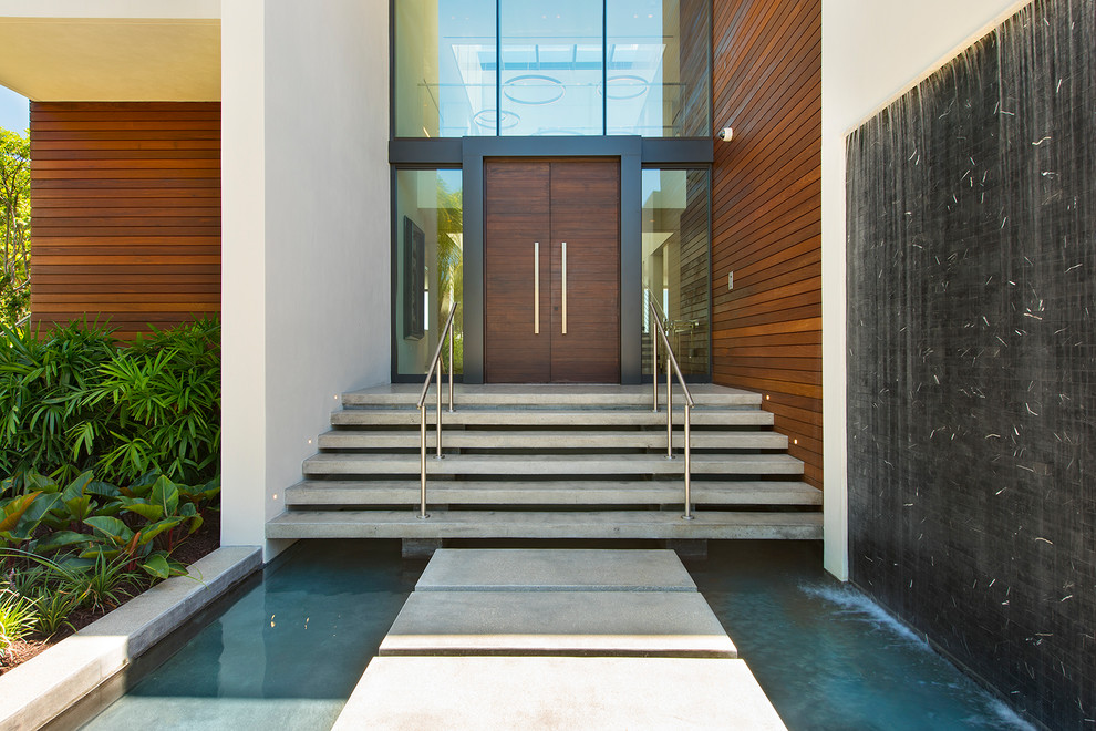 Photo of an expansive contemporary front door in Miami with a double front door and a dark wood front door.