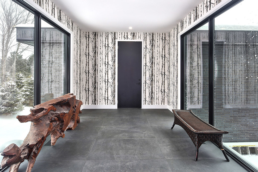 Esempio di un corridoio moderno di medie dimensioni con pareti beige, pavimento in ardesia, una porta singola, una porta nera e pavimento grigio