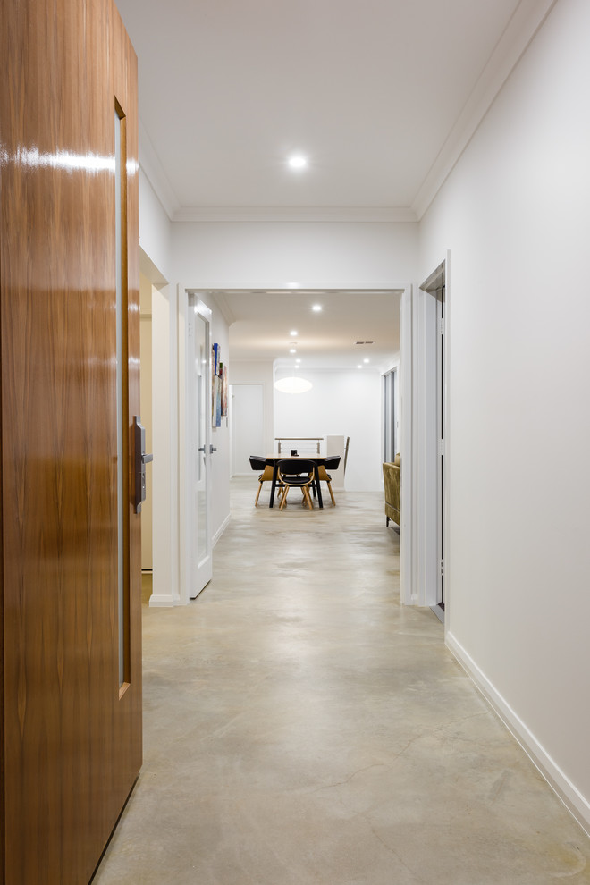 Moderner Eingang mit Betonboden, Korridor, weißer Wandfarbe, Drehtür, hellbrauner Holzhaustür und grauem Boden in Perth
