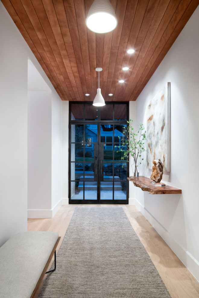 Großes Modernes Foyer mit weißer Wandfarbe, hellem Holzboden, Einzeltür, schwarzer Haustür, braunem Boden, Holzdielendecke und Holzdielenwänden in Austin