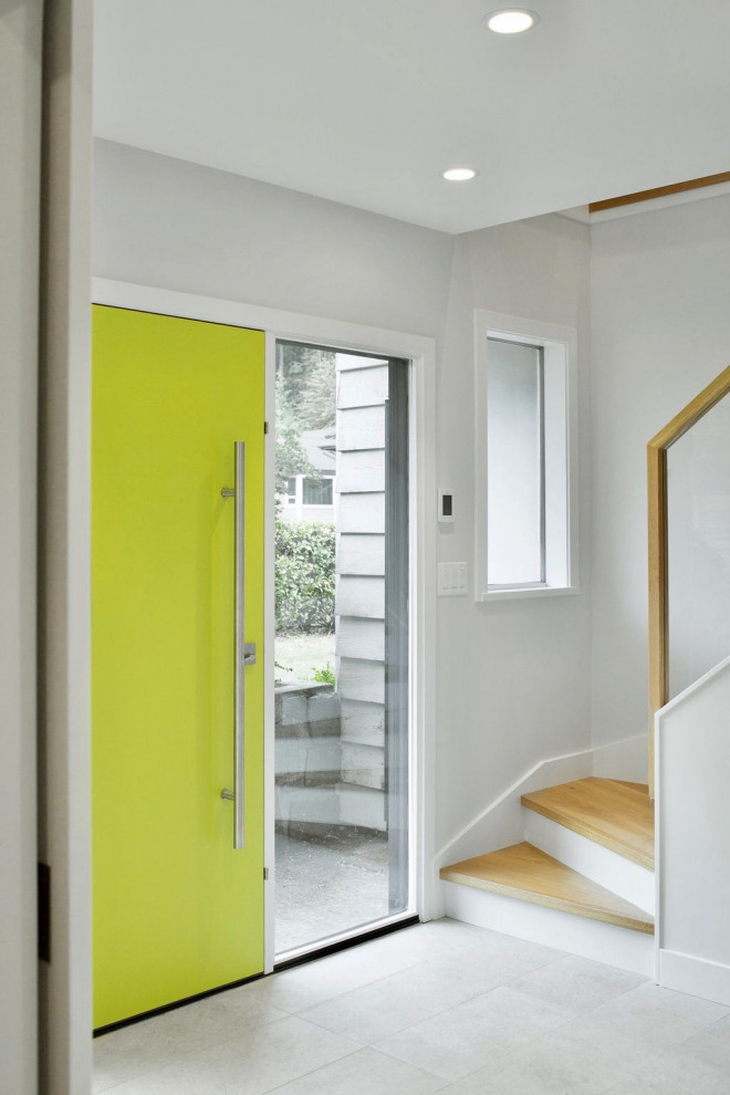 Bild på en mellanstor funkis ingång och ytterdörr, med vita väggar, klinkergolv i porslin, en enkeldörr, en grön dörr och grått golv