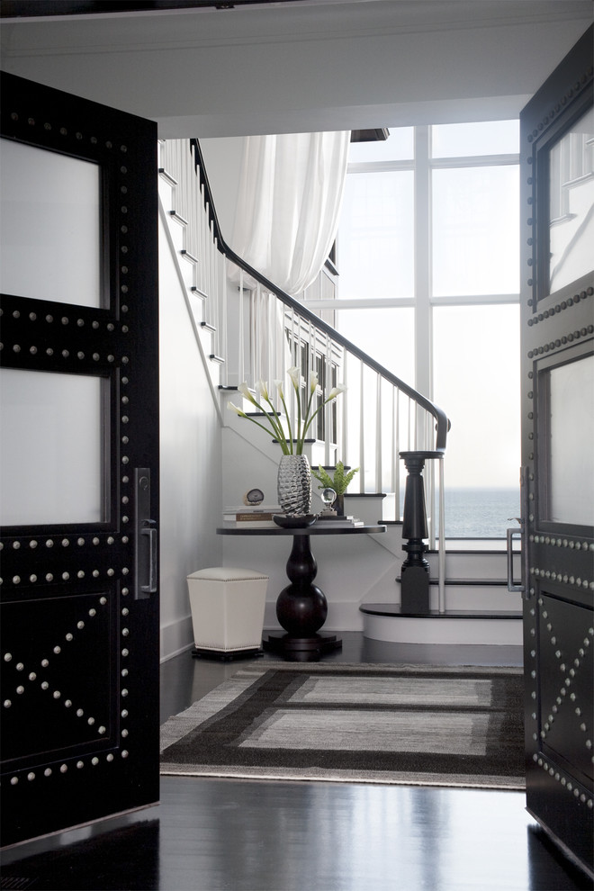 Example of a transitional dark wood floor and black floor foyer design in Boston with white walls