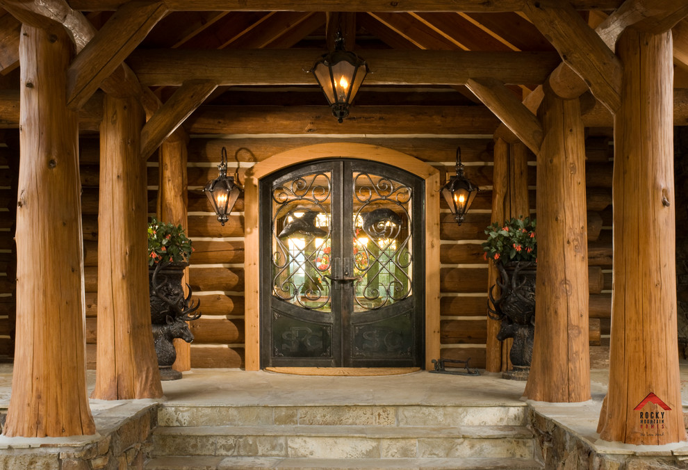 Immagine di un ingresso o corridoio stile rurale con pavimento in ardesia, una porta a due ante e una porta in metallo
