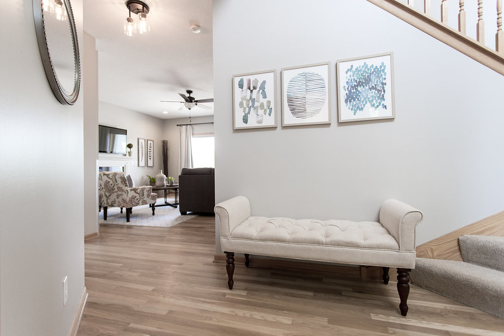 Idée de décoration pour une petite entrée design avec un couloir, un mur gris, parquet clair et un sol beige.