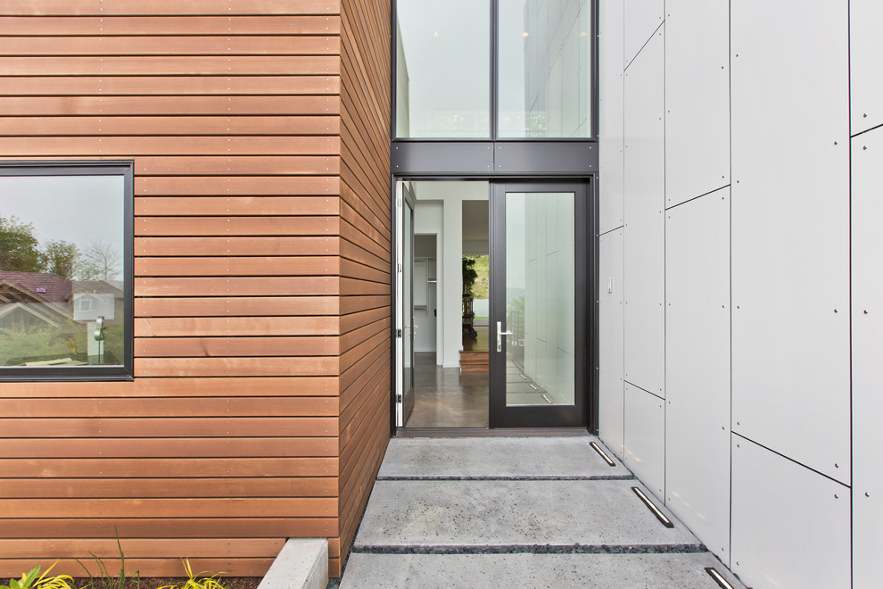 Mid-sized minimalist concrete floor entryway photo in Seattle with white walls and a glass front door