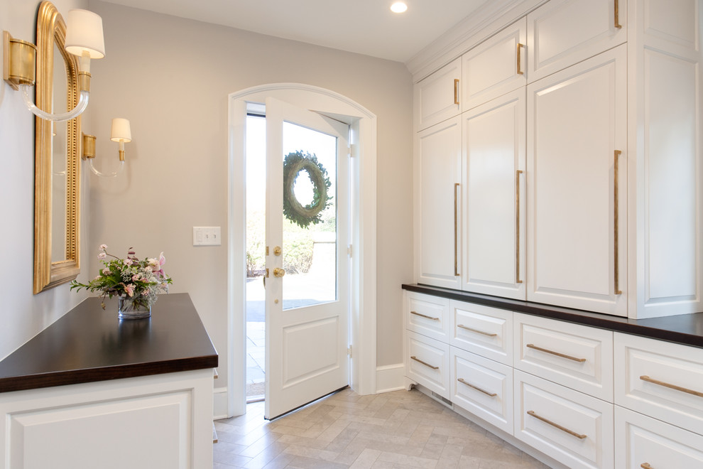 Example of a small transitional limestone floor and gray floor mudroom design in Richmond with gray walls and a white front door