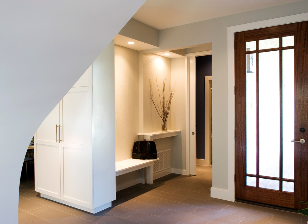This is an example of a medium sized modern foyer in Austin with white walls, porcelain flooring and a single front door.