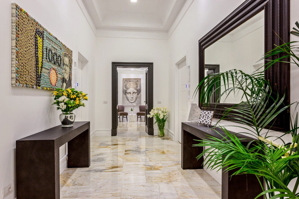 Aménagement d'une entrée contemporaine de taille moyenne avec un couloir, un mur blanc, un sol en marbre et un sol blanc.