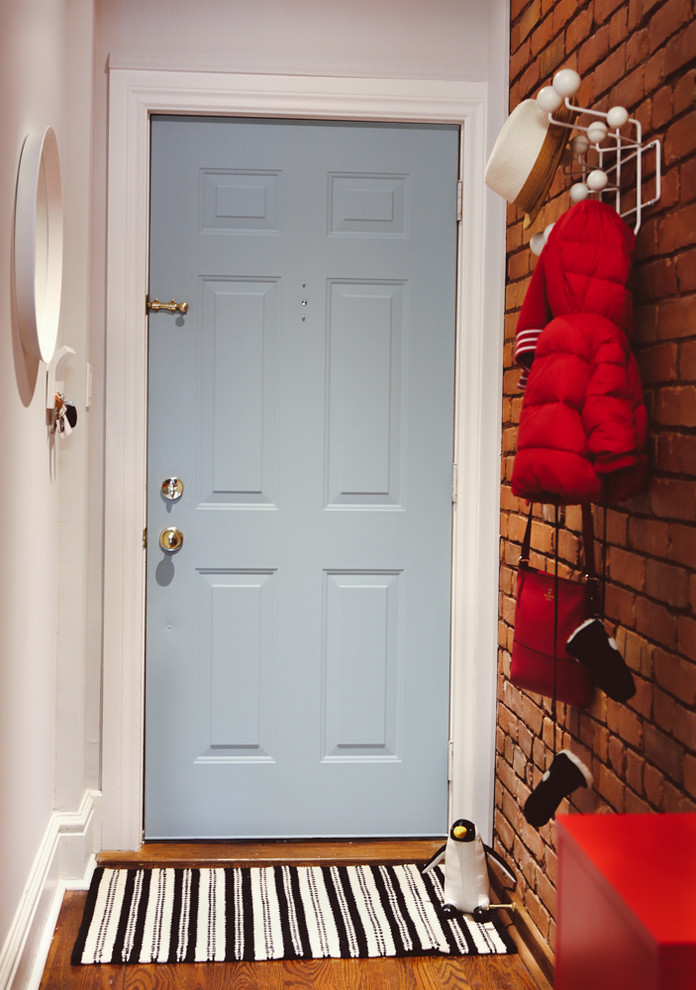 Exemple d'une entrée tendance de taille moyenne avec un couloir, un mur blanc, un sol en bois brun, une porte simple et une porte bleue.