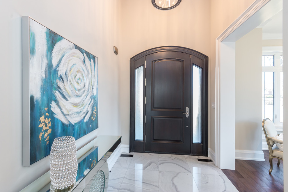 Стильный дизайн: входная дверь среднего размера в стиле неоклассика (современная классика) с бежевыми стенами, одностворчатой входной дверью, входной дверью из темного дерева и белым полом - последний тренд