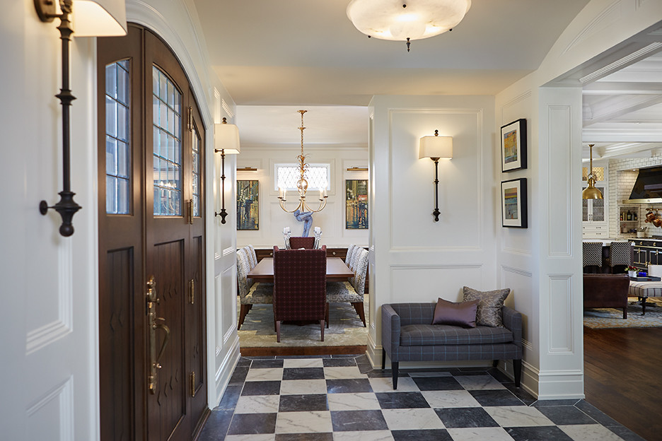 Example of a huge classic marble floor and multicolored floor entryway design in Grand Rapids with white walls and a dark wood front door