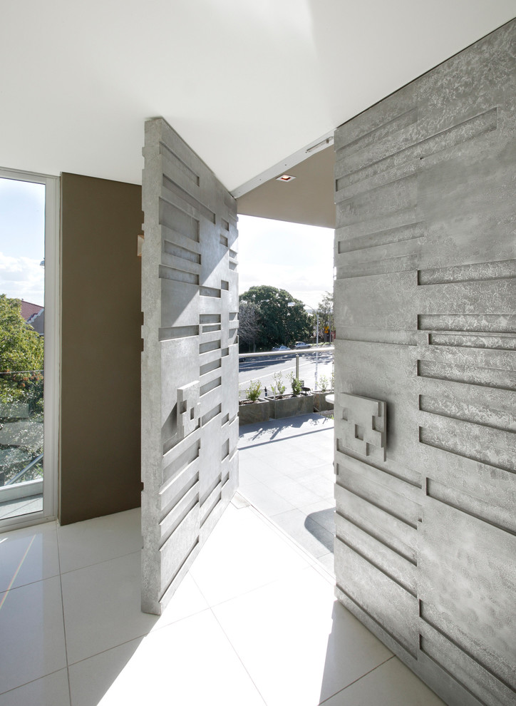 Idée de décoration pour une entrée design avec un mur marron, une porte simple et une porte grise.